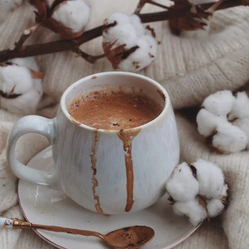 Hot chocolate in a ceramic cup with cotton flowers — illustrative serving or coffee study