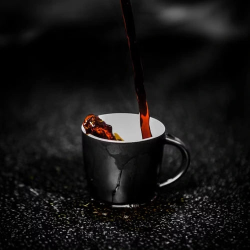 Fresh coffee pouring into a dark cup — illustrative serving or coffee study