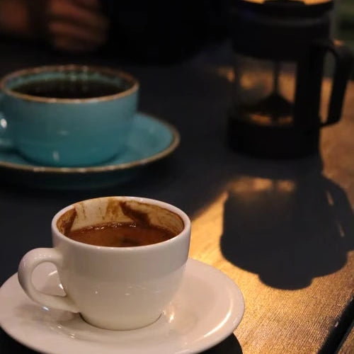 Coffee cups beside a French press — illustrative serving or coffee study