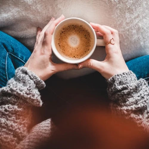 Hands holding a warm coffee cup — illustrative serving or coffee study