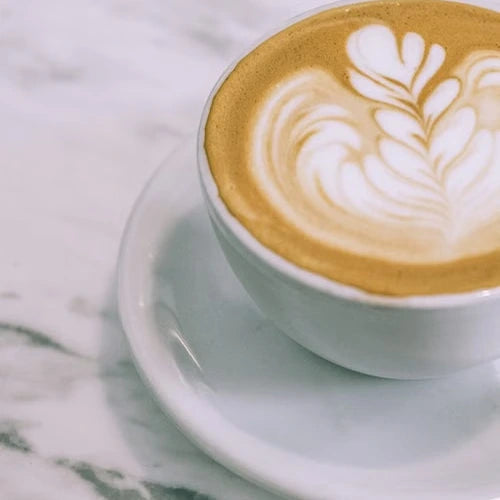Latte art in a ceramic cup on marble — illustrative serving or coffee study
