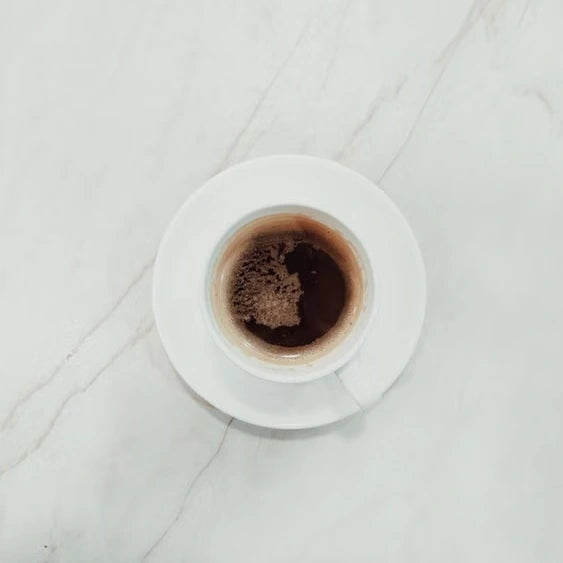 Espresso in a white cup on pale marble — illustrative serving or coffee study