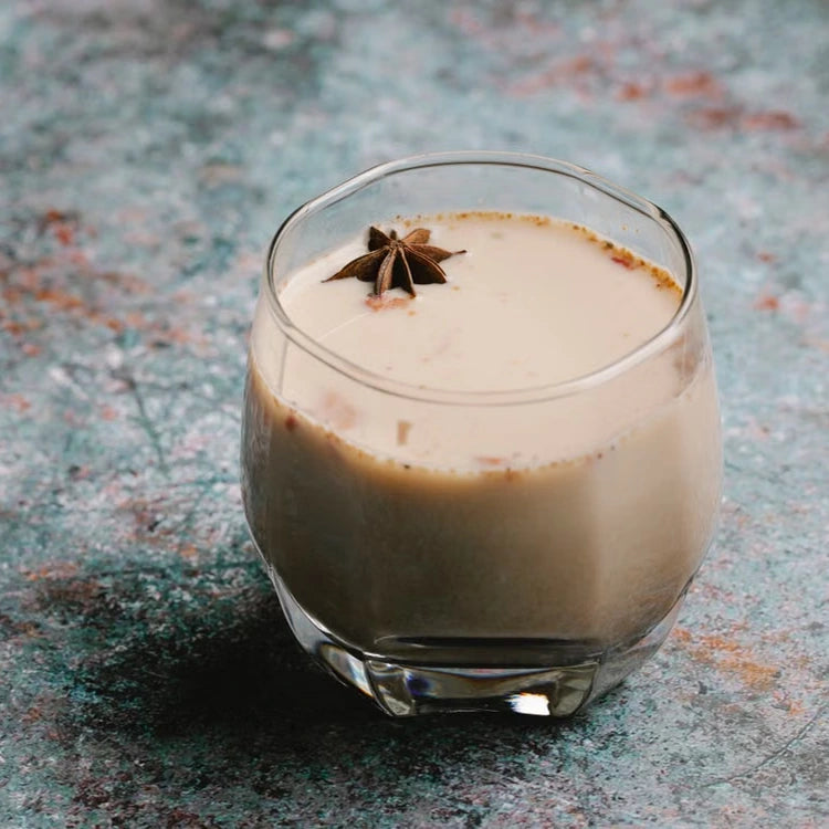 Chai latte in a glass with star anise — illustrative serving or coffee study