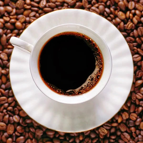 Black coffee in a white cup surrounded by roasted beans — illustrative serving or coffee study